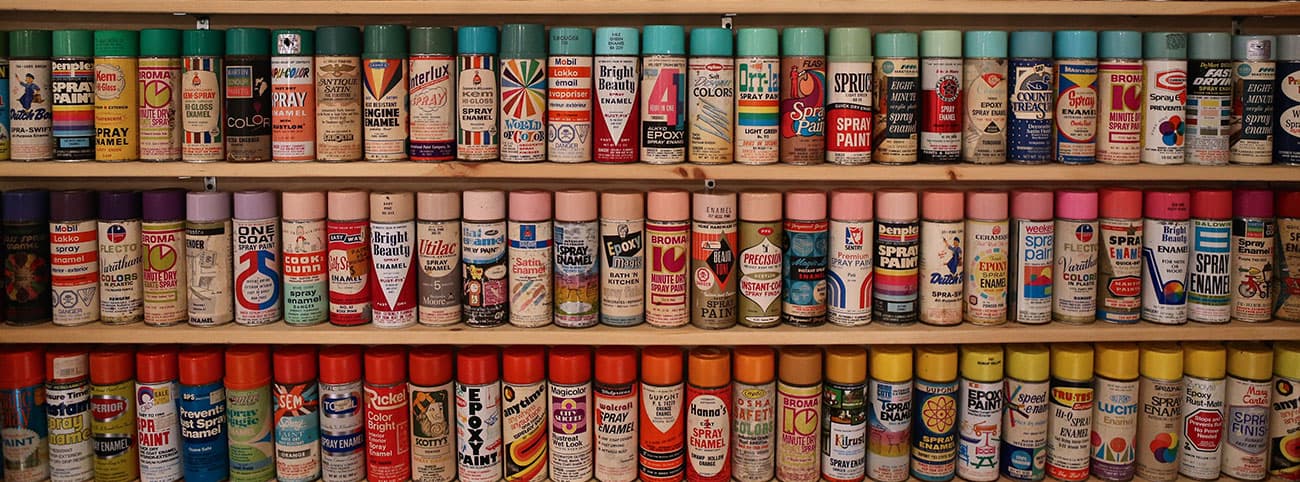 a shelving unit with hundreds of cans of spraypaint